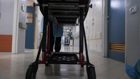 una camilla siendo empujada urgentemente en los pasillos del hospital