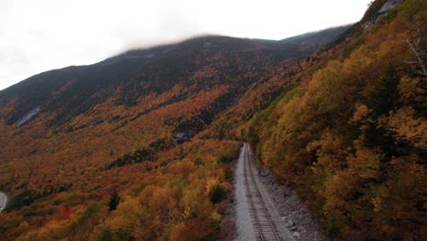 Antenne-Der-Bahngleise-In-Den-Bergen,-Umgeben-Von-Herbstlaub