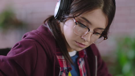 cerca joven mujer caucásica estudiante usando computadora portátil navegando en línea trabajando en un proyecto bebiendo jugo escuchando música en una oficina moderna de moda