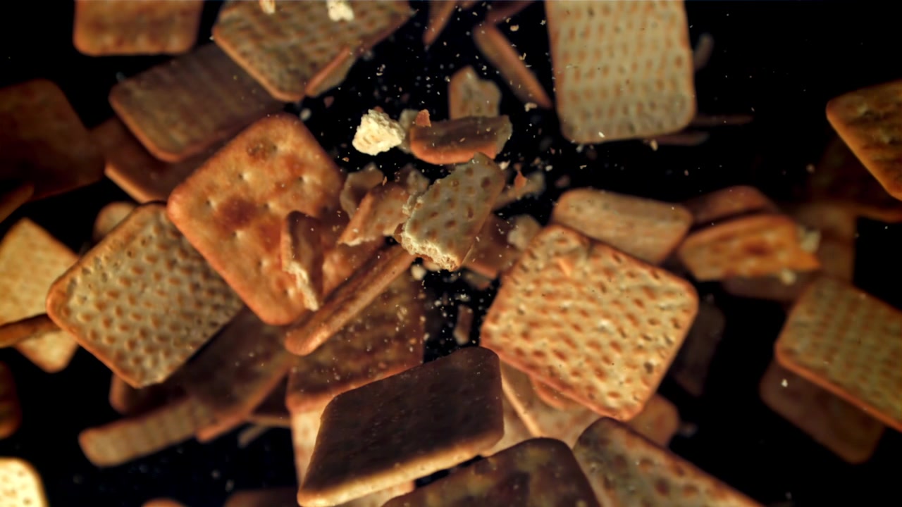 Cracker Quadrati Dorati che Cadono e si Sbriciolano al Rallentatore