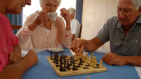 amigos mayores jugando al ajedrez.