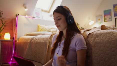 una adolescente estudiando en su dormitorio