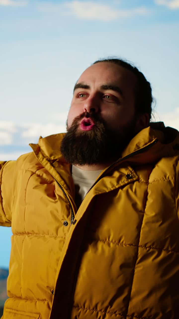 Happy Bearded Man in Yellow Puffer Jacket Enjoying Mountain View