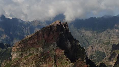 circular drone flight around one of the peaks of the madeira mountains near pico arieiro with the clouds in the sky