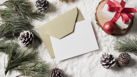 Vídeo-De-Adornos-Navideños-Y-Tarjeta-Blanca-Con-Espacio-Para-Copiar-Sobre-Fondo-De-Nieve