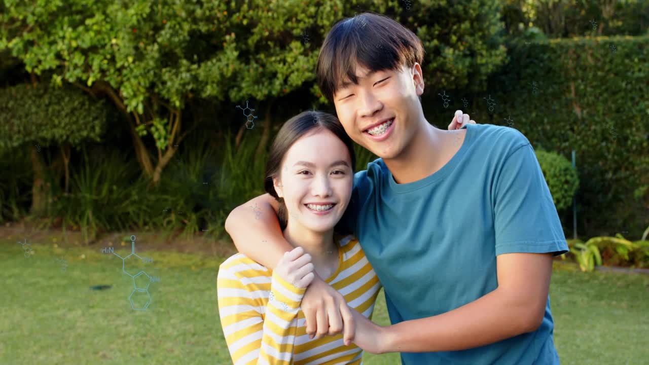Man reaching toward woman tapping, embracing lovingly on lawn, tech hexes hovering over couple