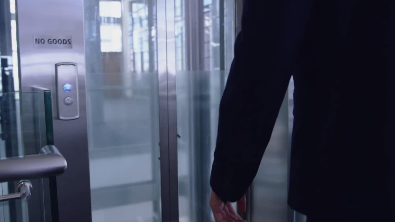 Businessman waiting for elevator in the corridor at modern office 4k