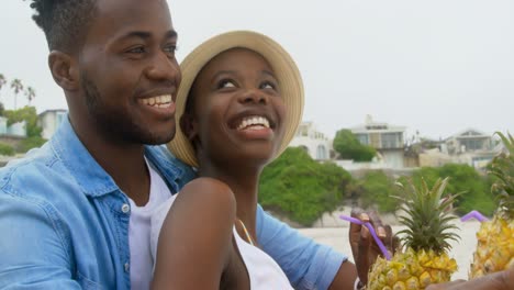 side view of african american couple interacting with each other on the beach 4k