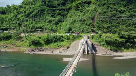 Person-Walking-On-Wooden-Hanging-Bridge-Across-River-In-Catanduanes,-Philippines