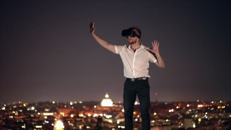 un joven creativo usa gafas de realidad virtual por la noche. esta nueva tecnología ofrece nuevas dimensiones 3d