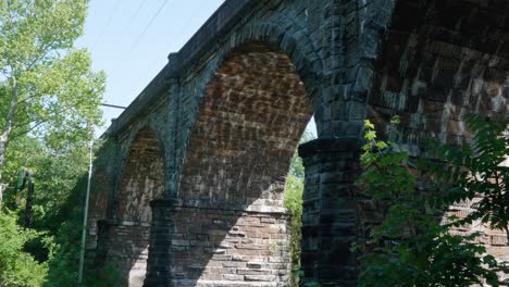 wasserreflexionen des sonnenlichts unter steinbahnbrücke, wissahickon creek