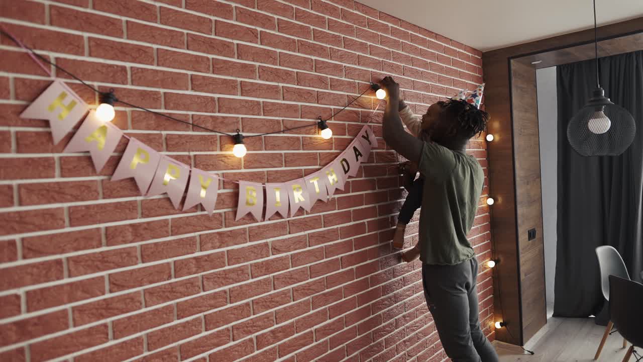 African American decorating together son's birthday party in the living room