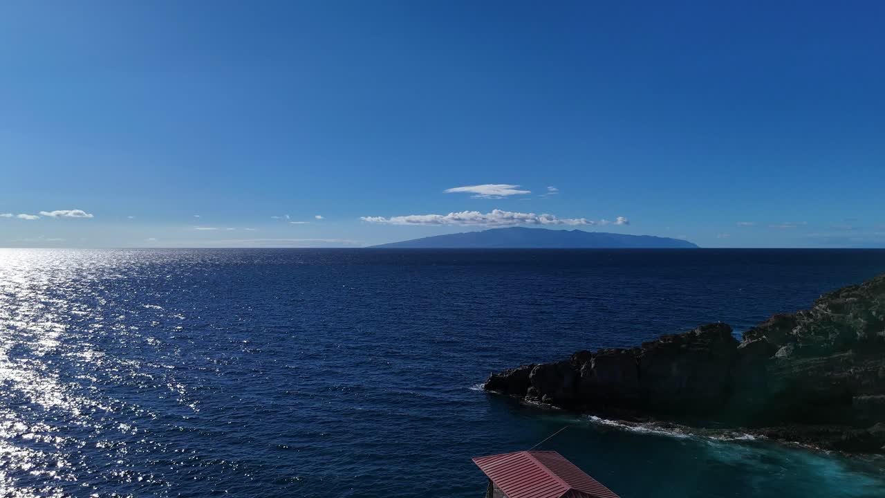 el puerto de balito de tenerife con vistas a la isla de la gomera en un clima tranquilo y soleado, vista aérea