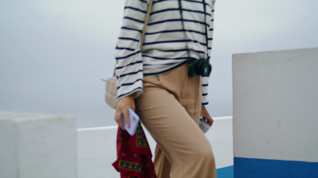 Tourist girl taking photos on smartphone vertical. Smiling blogger enjoying trip