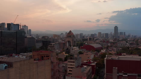 Forwards-reveal-and-tilt-down-footage-of-famous-Monument-to-Revolution-on-Plaza-de-la-Republica.-Historic-landmark-at-twilight-time.-Mexico-City,-Mexico.