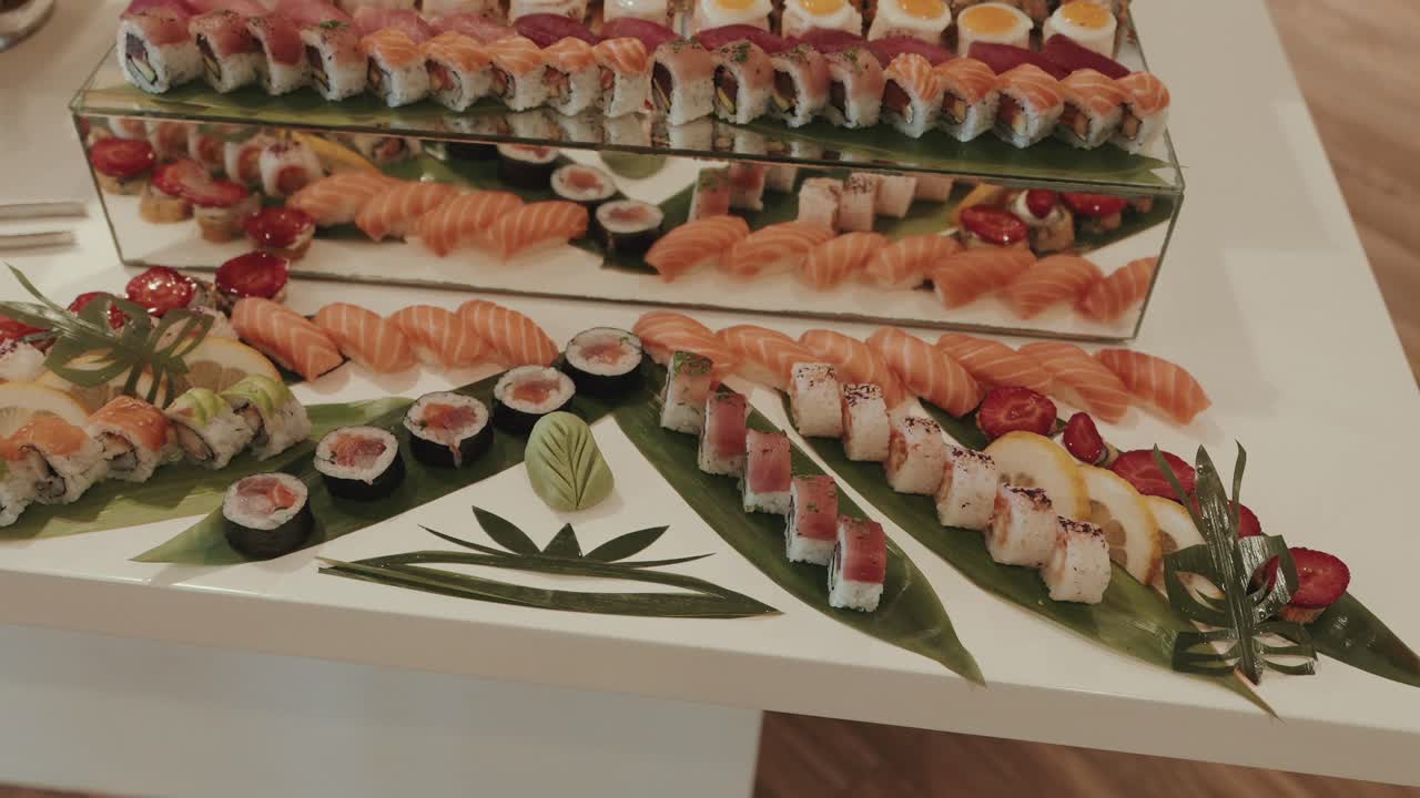 artistic sushi arrangement with mirrored display and intricate garnish on white modern table