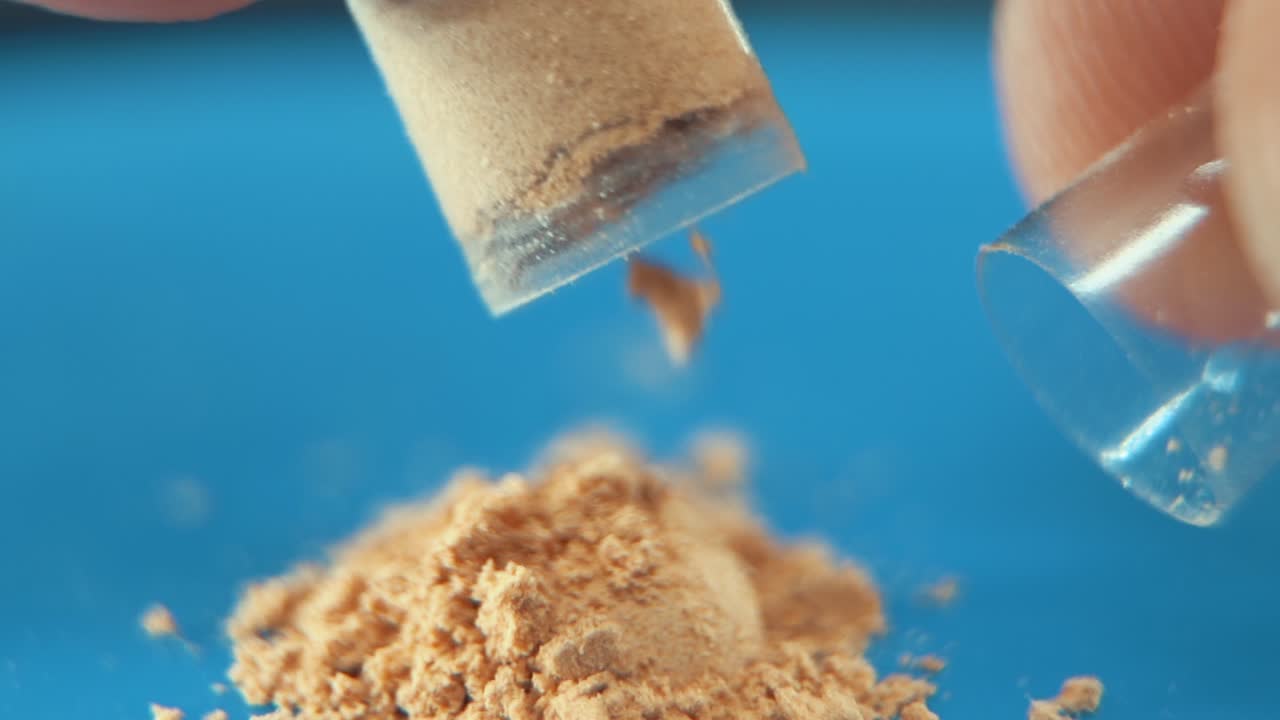 una macro en cámara lenta tomada en un laboratorio de una cápsula médica con polvo, píldoras orgánicas, luz de estudio, 120 fps, full hd