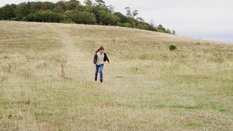 vista frontal de una chica en una actividad al aire libre, un viaje de campamento corriendo por la colina