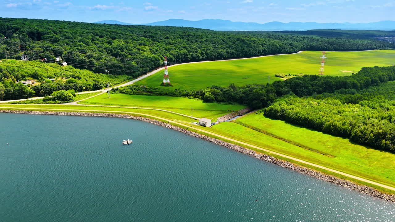 Scenic lake view in Europe. A serene lake surrounded by lush greenery and rolling hills in a peaceful European landscape during bright daylight