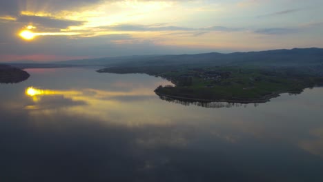 Hermosa-Luz-Del-Sol-Sobre-El-Lago-Czorsztyn-En-Polonia,-Vista-Trasera-De-Drones