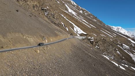 aerial siguiendo un coche de jeep fuera de carretera conduciendo en kazah en el valle de spiti en el himalaya en la india