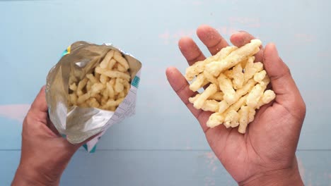 holding a open potato chips packet top view