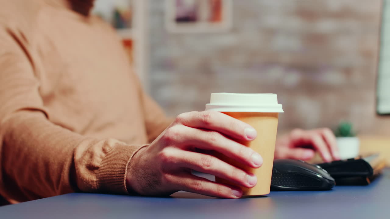 Close up of male engineer picking up his coffee