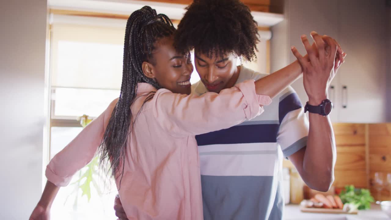 Happy african american couple dancing together in log cabin, slow motion