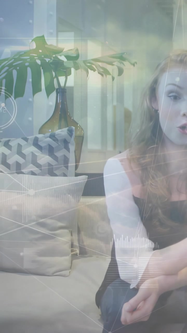 Vertical video: Woman answering prompt, placing cup and smiling while tech HUD tracing gestures