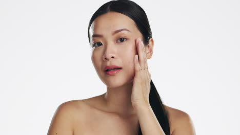 Skincare,-asian-woman-and-touch-face-in-studio