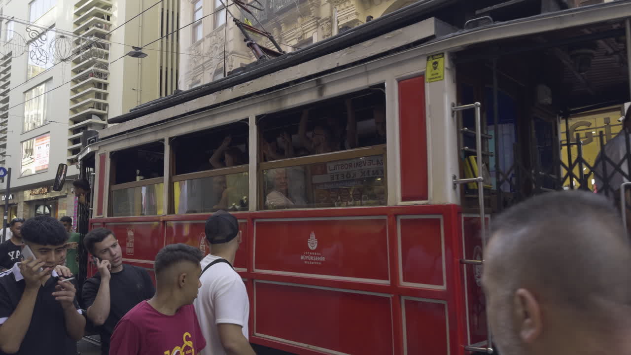 Establishing shot of a bustling street scene along Independence Avenue with pedestrians, local shops, and vibrant city life