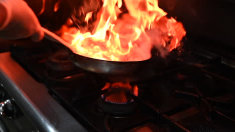 stir fry the beef strips in a saucepan on the gas stove of a restaurant kitchen