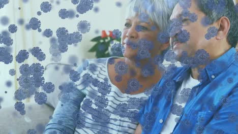Animation-of-mixed-race-couple-at-home-during-coronavirus-covid19-pandemic-with-spreading-cells