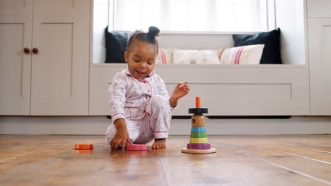 Smiling-Female-Toddler-At-Home-Playing-With-Wooden-Stacking-Toy