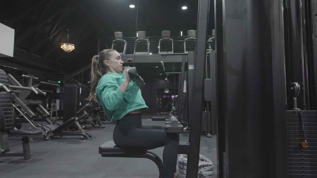 A woman performing lat pulldowns at the gym