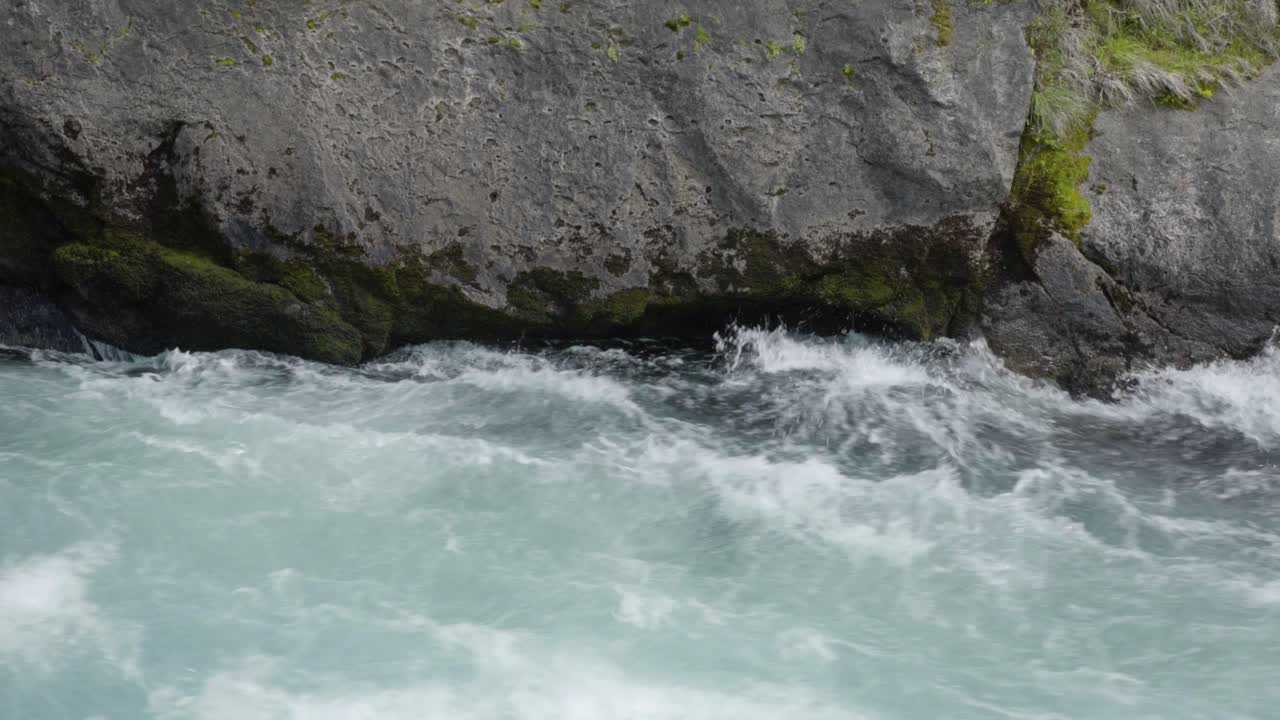 Et nærbillede af vildt vand, der strømmer forbi en sten i Huka Falls i Taupo, NZ