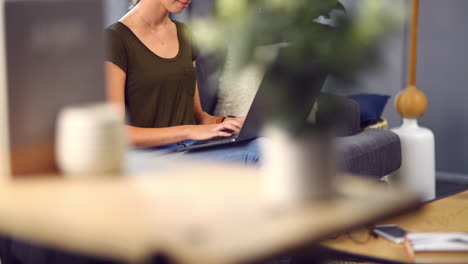 una mujer joven atractiva usando su computadora portátil