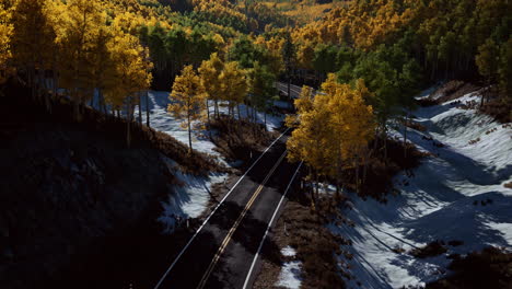 aérea sobre una sinuosa carretera forestal en finlandia durante la puesta de sol