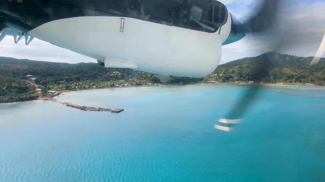 Vista aerea dal finestrino di un aereo a elica dell'isola tropicale di Kadavu nelle Fiji, Pacifico meridionale, con panorami mozzafiato della costa e dell'acqua turchese dell'oceano