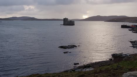 Shot-of-the-historic-Kisimul-Castle-and-the-ocean-around-Castlebay-on-the-island-of-Barra-on-an-overcast-evening