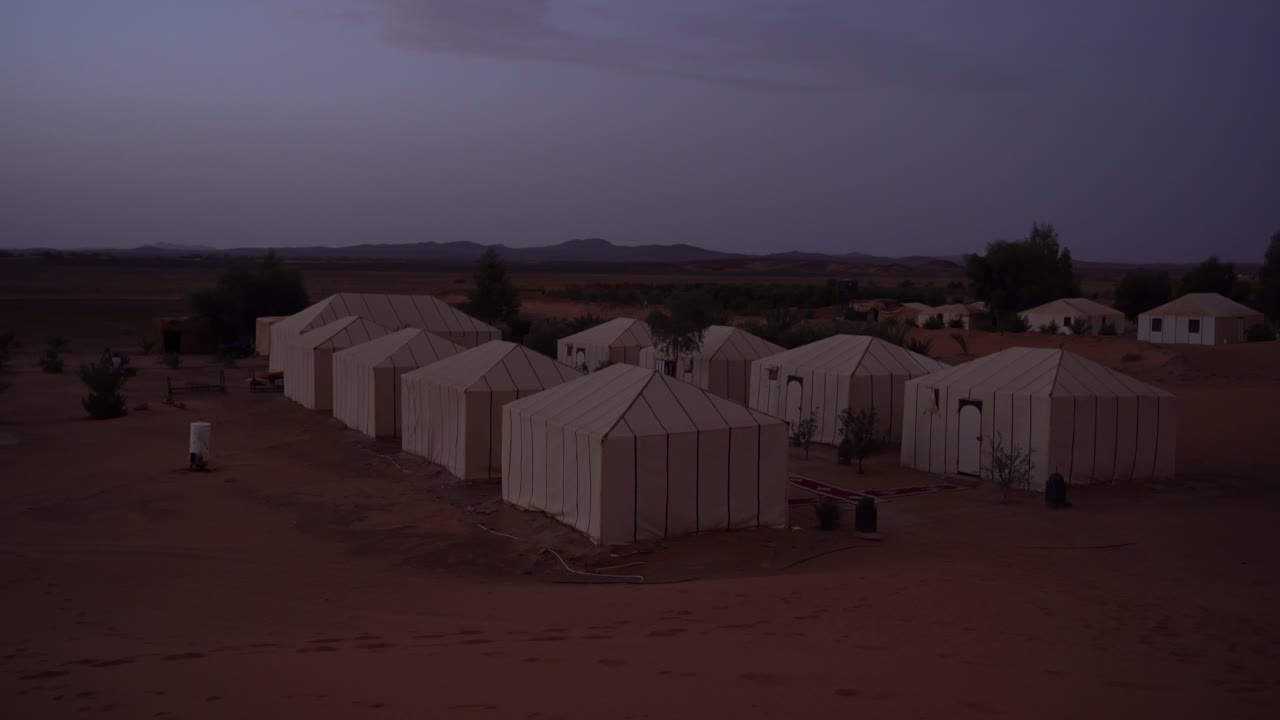 la vista del campamento del desierto desde las dunas en marruecos, merzouga, áfrica