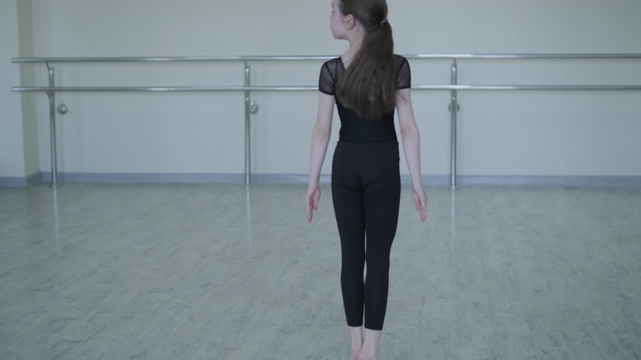 スタジオでダンスの動きを練習する若いバレリーナ