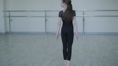 young ballerina practicing dance moves in studio