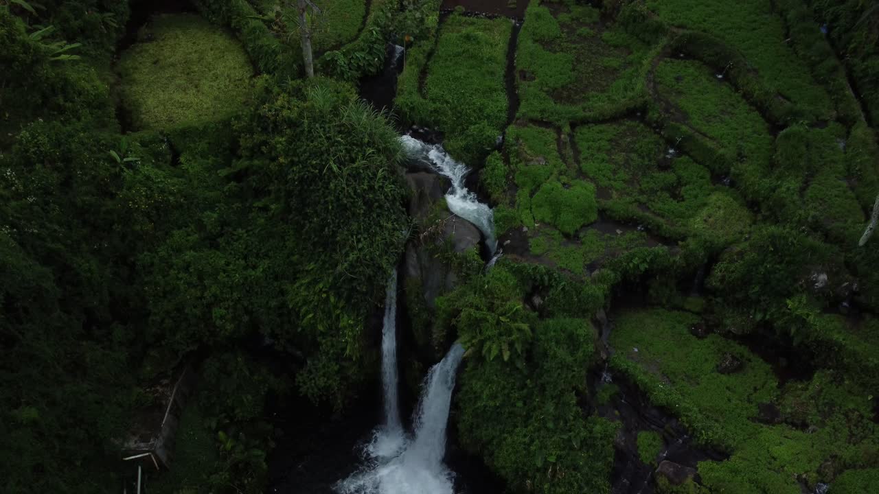 la cascada gemela de arum con un disparo aéreo de avión no tripulado bajando a la piscina de abajo con un paisaje de vegetación escénica