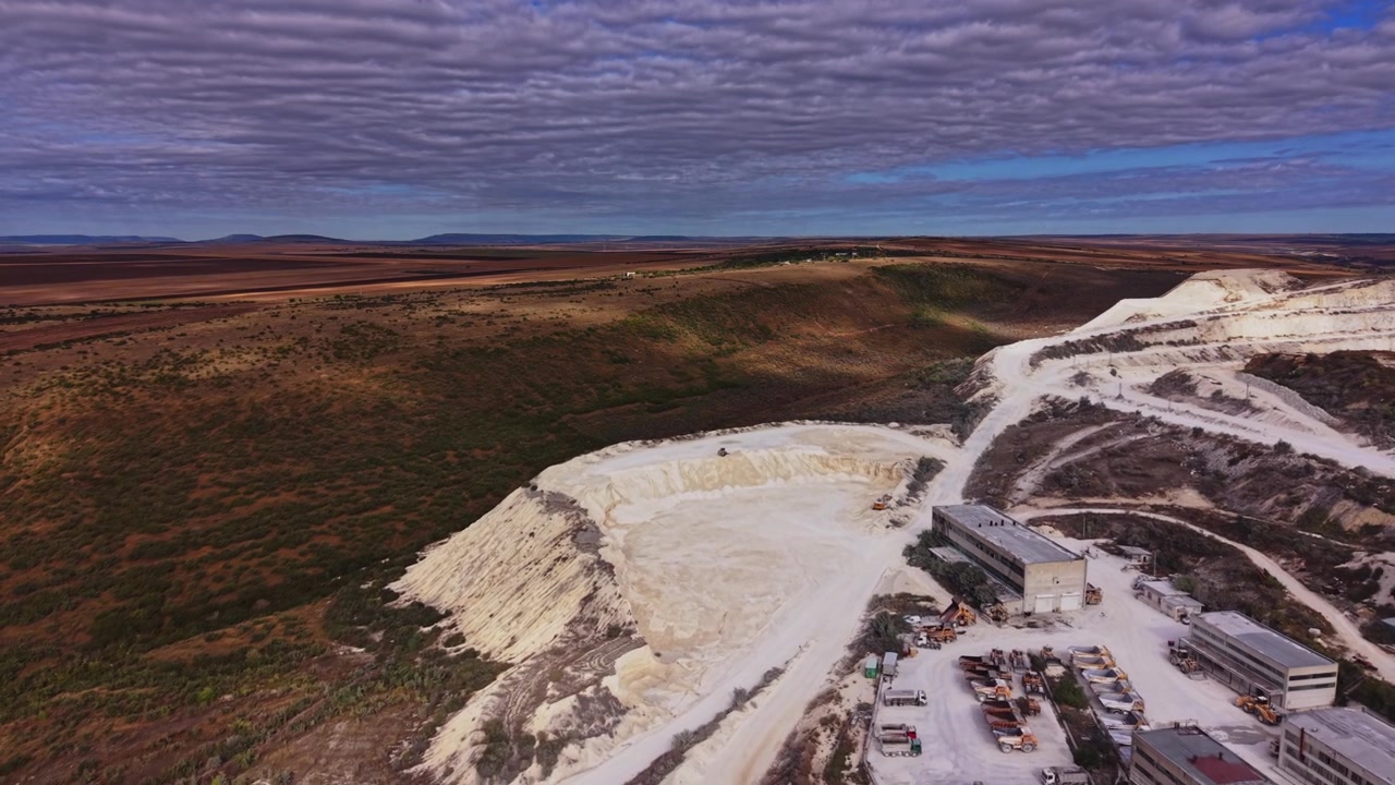 Landscape view of quarry in rural area with heavy machinery in motion