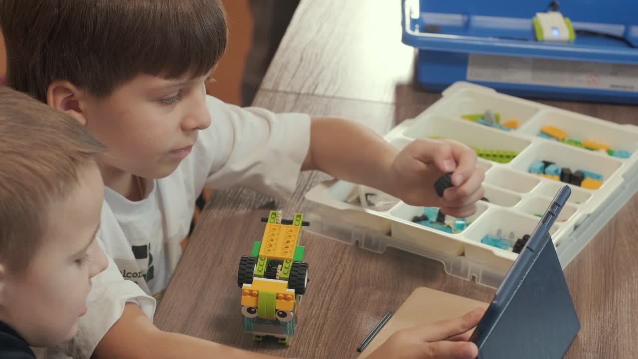 los niños participan en actividades de aprendizaje básico, montando kits de robótica con enfoque y trabajo en equipo en un entorno de aula