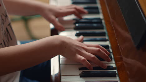 close up of unidentified hands playing piano indoors. pianist hands practicing.