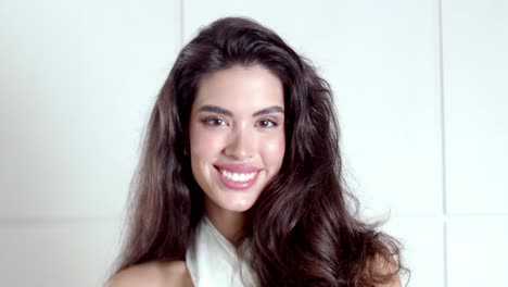 una joven irradia positividad y una hermosa sonrisa alegre hacia la cámara.