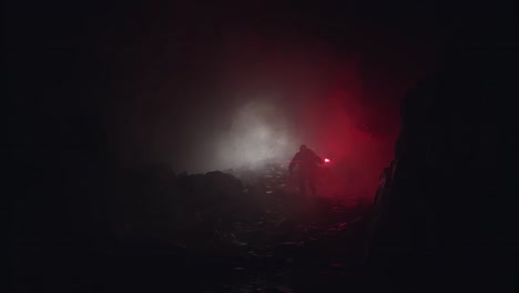 person exploring a dark cave at night with a red light