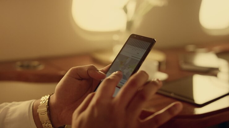 Manager di successo che controlla le statistiche finanziarie. Mani che toccano lo smartphone, primo piano.